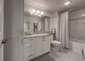 Thumbnail 3 of 8 - Lux Apartments Bellevue bathroom with inset sink in quartz countertops and ample storage including a below sink cabinets and a linen closet