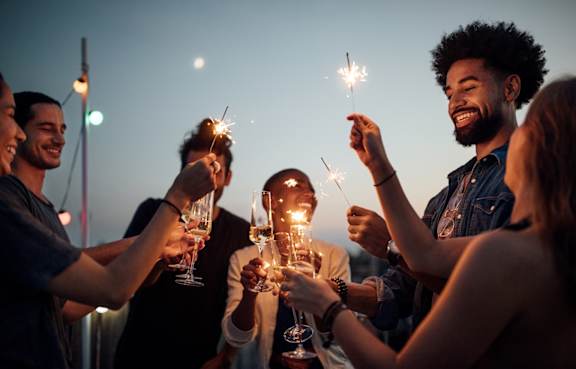 A group of people holding sparklers at a party.