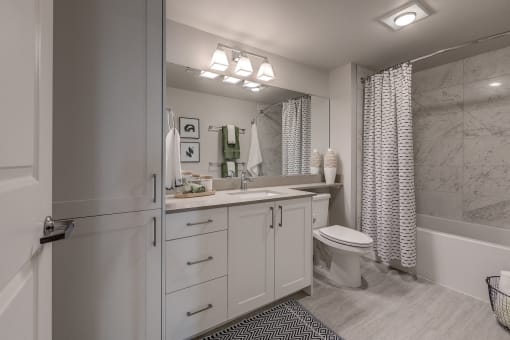 Lux Apartments Bellevue bathroom with inset sink in quartz countertops and ample storage including a below sink cabinets and a linen closet