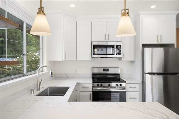 a kitchen with a sink and a stove and a refrigerator