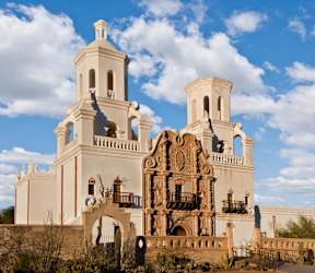 A large white church with two towers and a balcony.