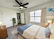 Thumbnail 2 of 15 - A bedroom with a large bed and a ceiling fan.