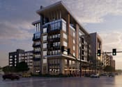 Thumbnail 4 of 4 - A modern apartment building with cars parked in front.