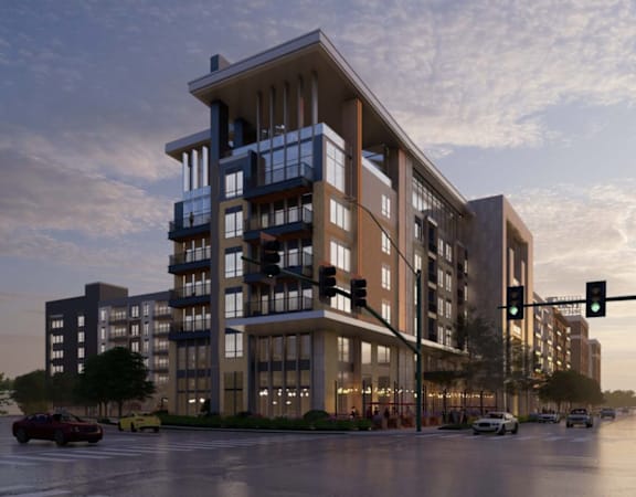A modern apartment building with cars parked in front.