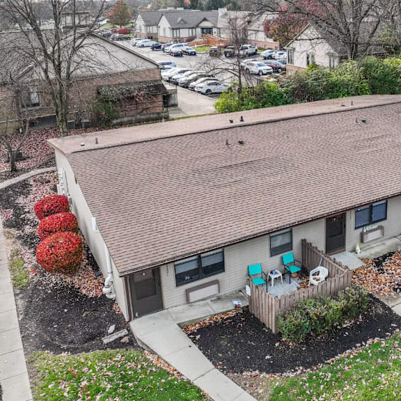 A house with a brown roof and a white fence.