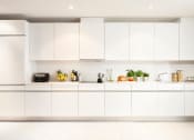 Thumbnail 2 of 7 - a white kitchen with white counters and white cabinets