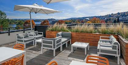 A patio with a table and chairs overlooking a body of water.