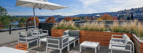 A patio with a table and chairs overlooking a body of water.