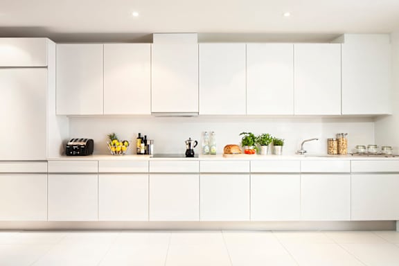 a white kitchen with white counters and white cabinets