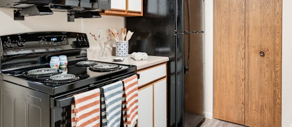 A black stove with a black microwave above it.