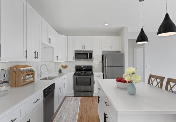 a large white kitchen with stainless steel appliances and white cabinets
