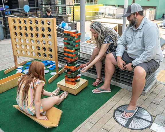 a family playing a game on a large game board
