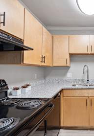 a kitchen with wooden cabinets and granite counter tops and a stove and sink