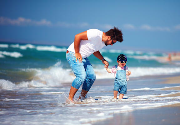 Dad and child playing in the waves Eagles Pointe in Pompano Beach Florida at Eagle Pointe, Pompano Beach, FL