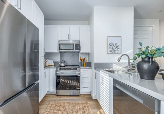 A modern kitchen with a stainless steel refrigerator and white cabinets.