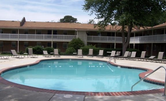 a swimming pool in front of a hotel building