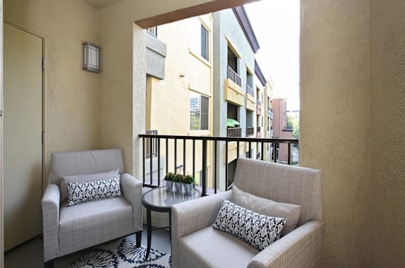 A balcony with two chairs and a table at The Kitt at Warner Center in Woodland Hills, CA