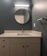 A bathroom with a toilet, sink, and mirror.