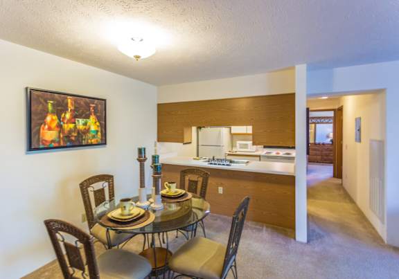 a dining room and kitchen with a table and chairs