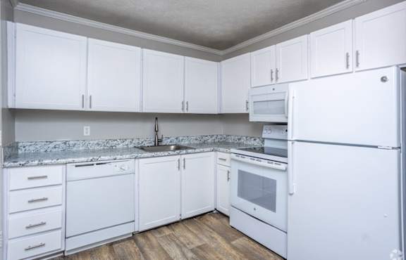 A kitchen with white cabinets and appliances.