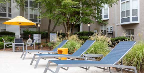 A row of sun loungers are arranged in a row in front of a building.