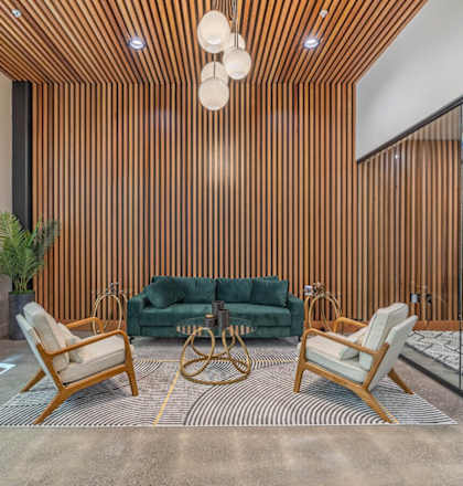 a living room with a green couch and two chairs