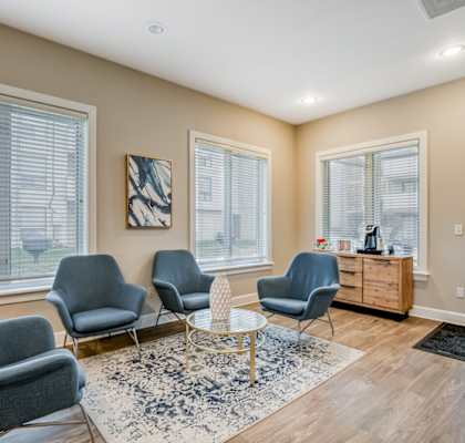 A living room with grey chairs and a white table.