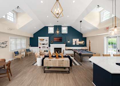 A large open living room with a fireplace and a pool table. at Spa Cove Apartments, Annapolis, 21403