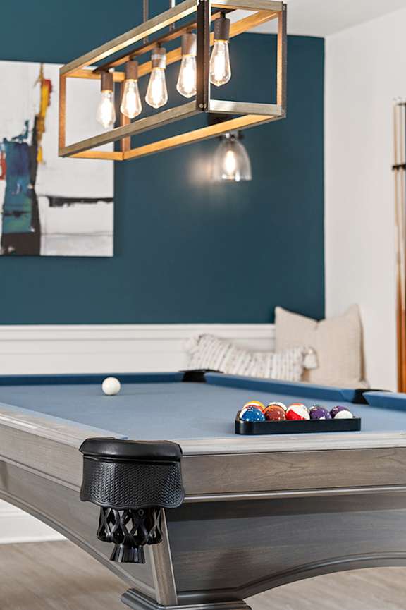 A pool table with a lighted billiard light above it. at Spa Cove Apartments, Annapolis, 21403