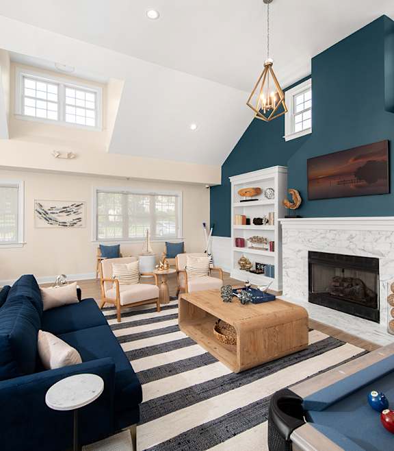 A blue sofa and a pool table are in the middle of a room with a fireplace. at Spa Cove Apartments, Annapolis, 21403