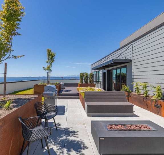 the outdoor patio has a view of the water and the house