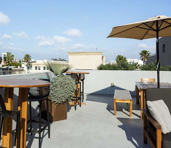 A patio with a table, chairs, and an umbrella.
