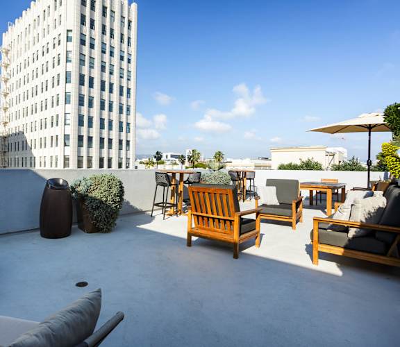 A patio with chairs and a table with a view of a tall building.