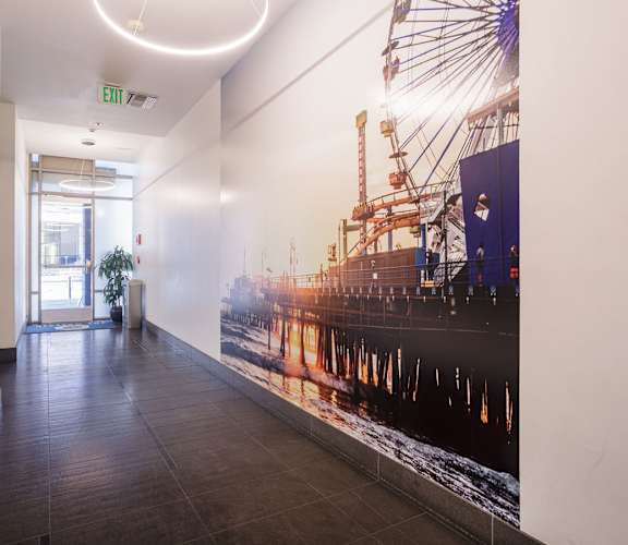 A long hallway with a large poster of a ship on the wall.