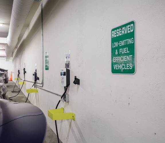 A sign in a parking garage designates a spot for low-emission vehicles.