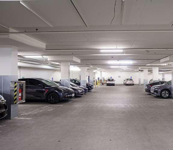 A parking garage with several cars parked.