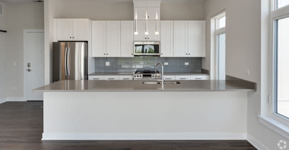 a kitchen with white cabinets and a large counter top