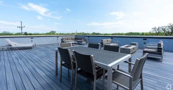a patio with a table and chairs on top of a roof