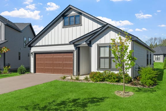 a house with a gray roof and a brown garage door