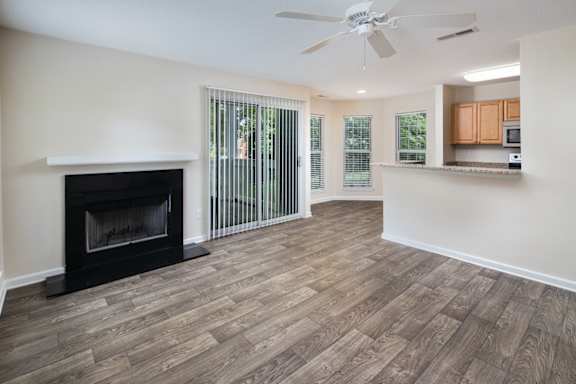 A room with a fireplace and wood flooring.