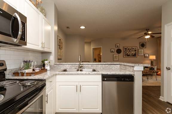 A kitchen with white cabinets and a black stove top oven.