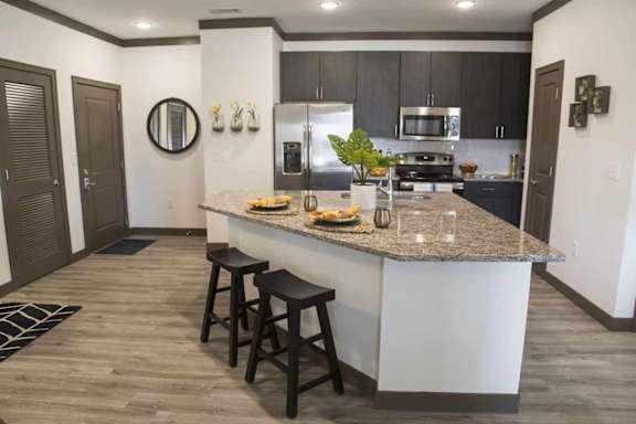 A kitchen with a bar stool in front of the island.