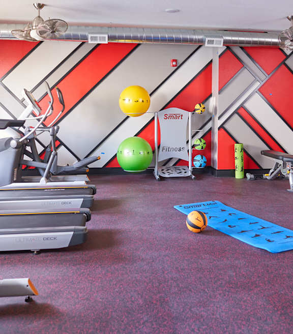a gym with treadmills and other exercise equipment on the floor and a ball at Vue Apartments, Des Moines, IA 50309