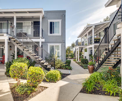 an exterior view of apartments with stairs and landscaped gardens