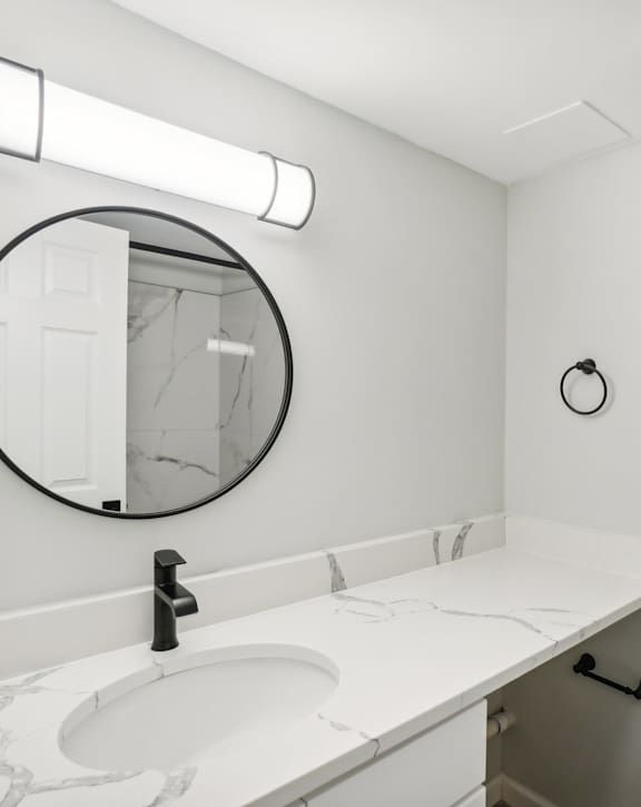 A bathroom with a white sink and toilet. at The Park on 13 Apartments - Royal Oak, MI Apartments, Royal Oak, MI, 48073