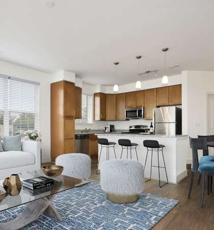 a living room with a white couch and a coffee table in front of a kitchen with a