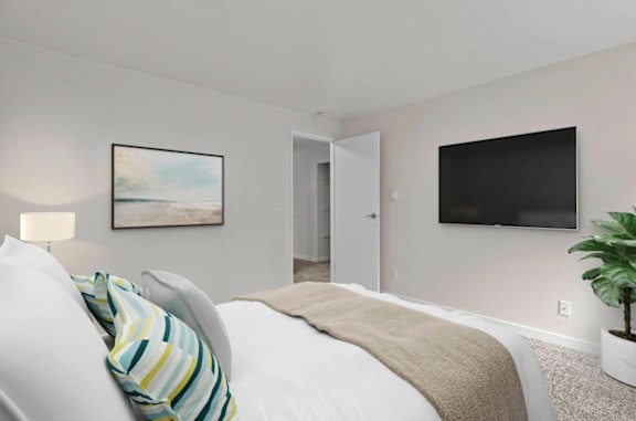 A bedroom with a bed, a painting, a door, and a plant  at Brackett Apartment, WA, 98020