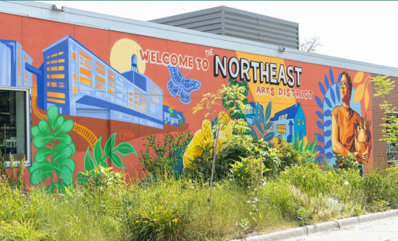 a mural on the side of a building that says welcome to northeast