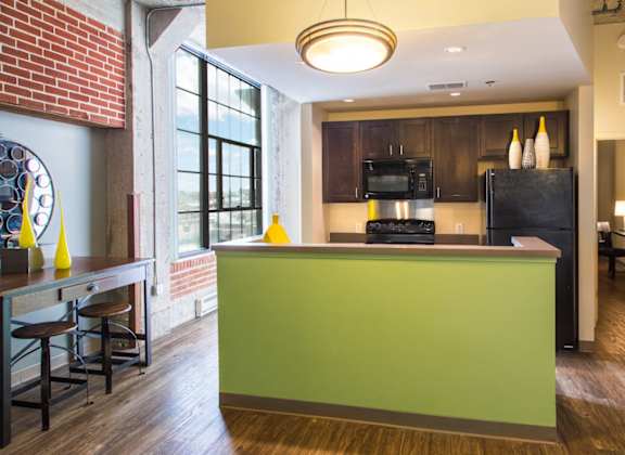 a kitchen with a green counter and a black refrigerator