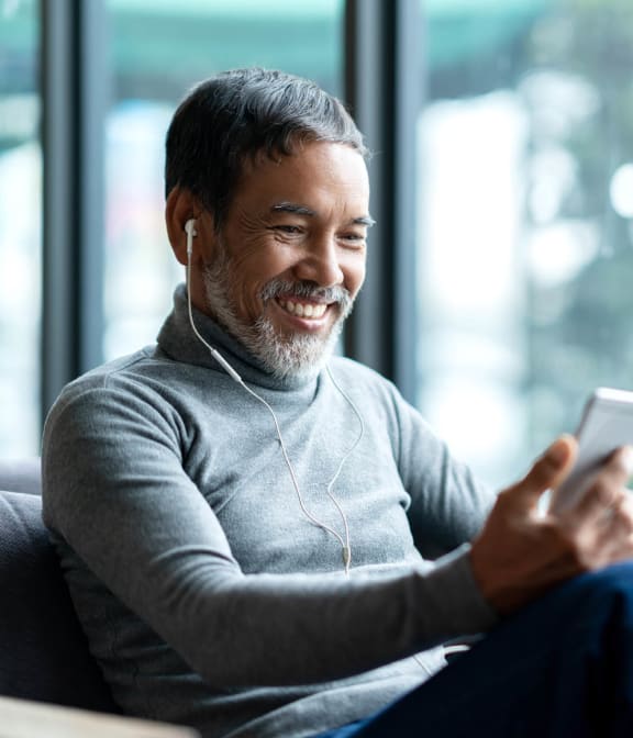 Man smiling at phone while listening to music